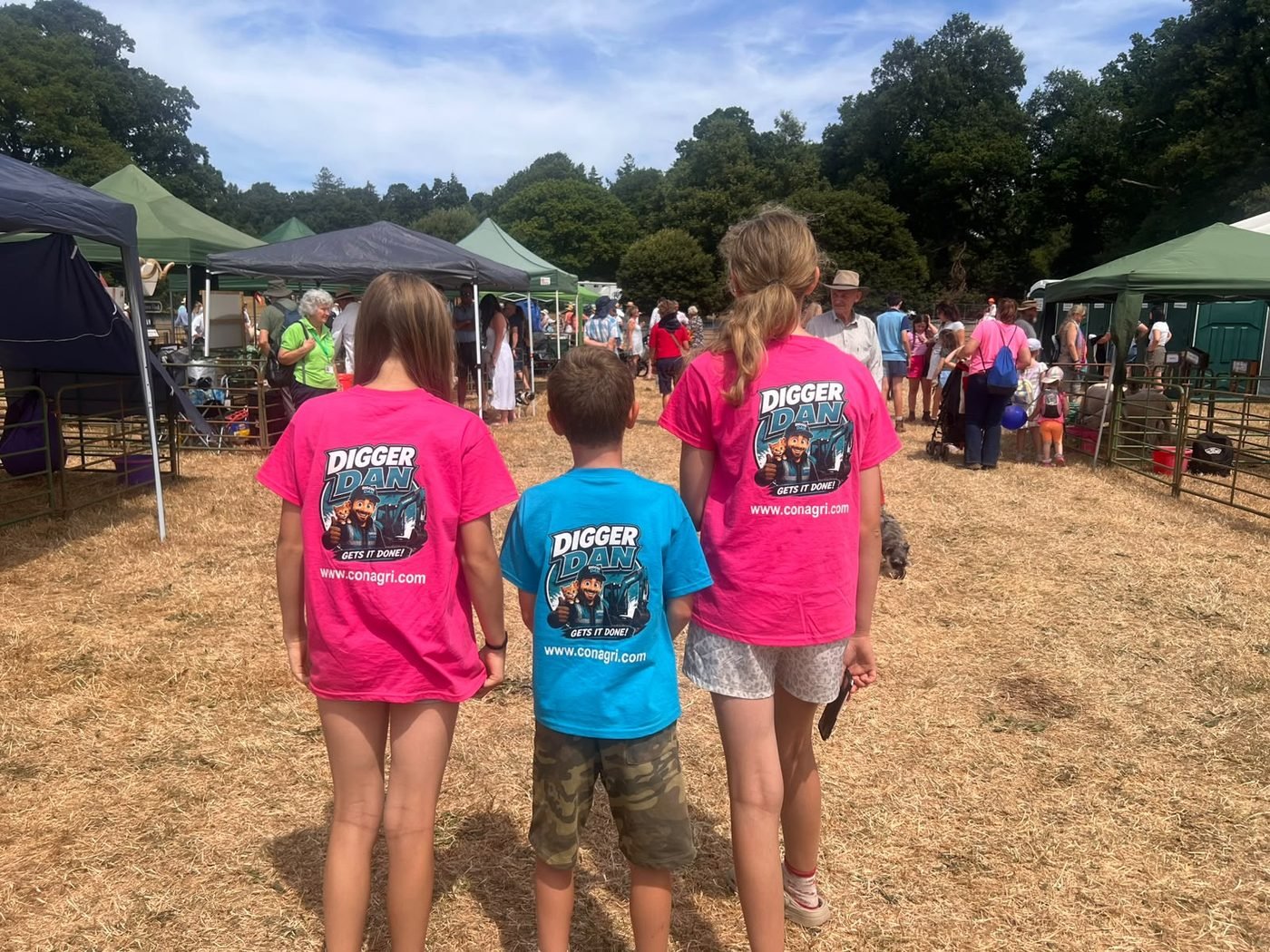 Three young fans wearing official Digger Dan t-shirts in pink and blue
